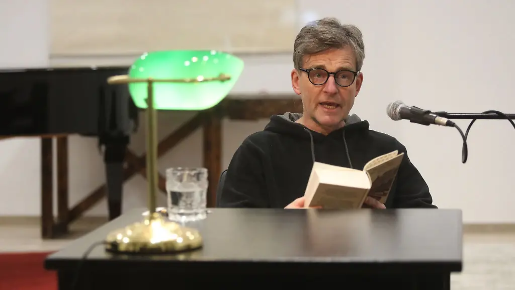 Schauspieler-Jochen-Fahr-liest-in-einem-Schaufenster-aus-dem-Buch-Der-Zauberberg