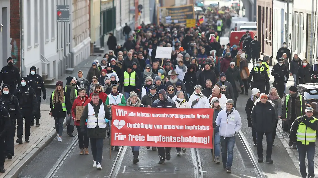 Teilnehmer-einer-Demonstration-gegen-Corona-Einschraenkungen-laufen-durch-Schwerin