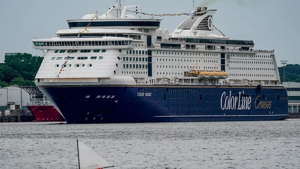 Ein-Segelboot-faehrt-an-der-Color-Magic-die-aus-dem-Hafen-von-Kiel-auslaeuft-vorbei