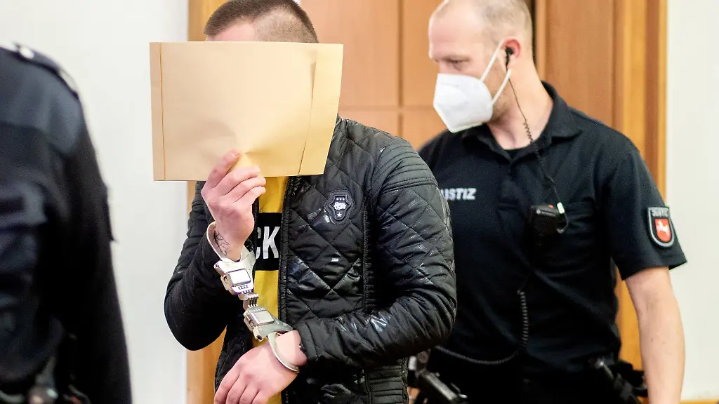 Der-Angeklagte-wird-mit-Handfesseln-in-einen-Saal-im-Landgericht-gefuehrt