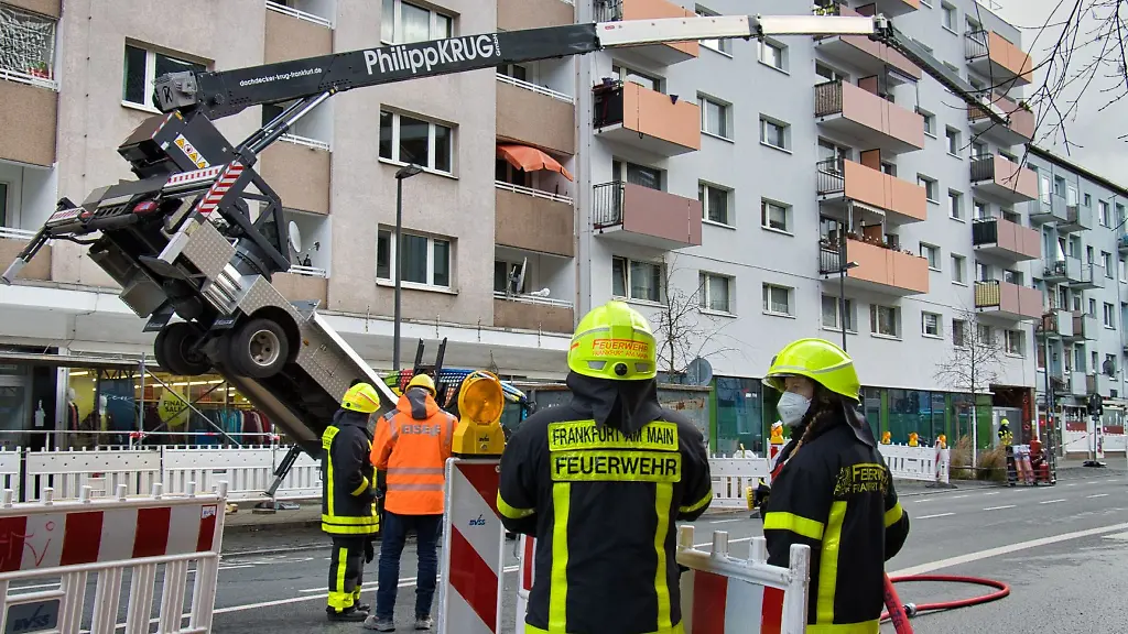 Feuerwehr-Einsatzkraefte-stehen-vor-einem-umgekippten-Kran