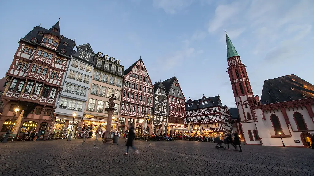 Nur-wenige-Menschen-flanieren-am-Abend-ueber-den-Roemerberg-in-Frankfurt