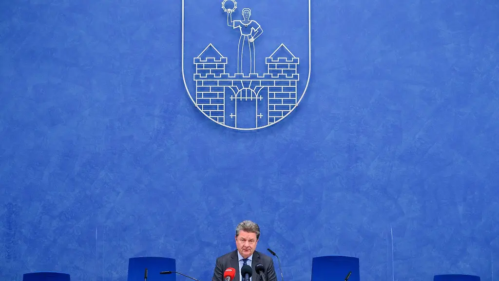 Magdeburgs-Oberbuergermeister-Lutz-Truemper-sitzt-unter-dem-Wappen-der-Stadt