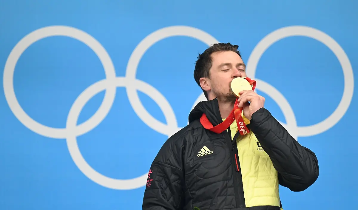 Der-35-jaehrige-Rodler-Johannes-Ludwig-feiert-mit-seiner-Goldmedaille-auf-dem-Podium
