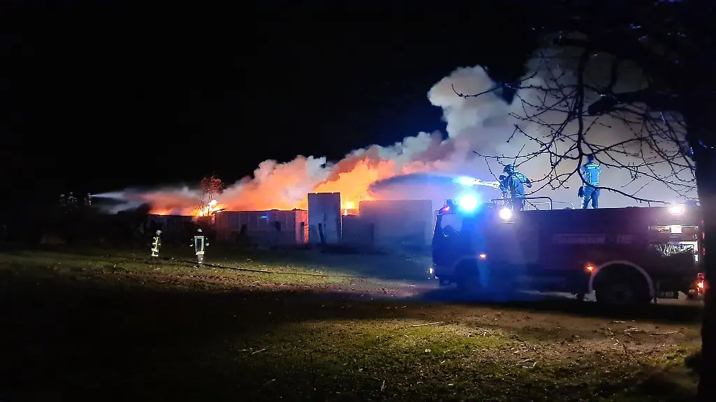 Einsatzkraefte-der-Feuerwehr-loeschen-einen-grossen-Altreifenbrand