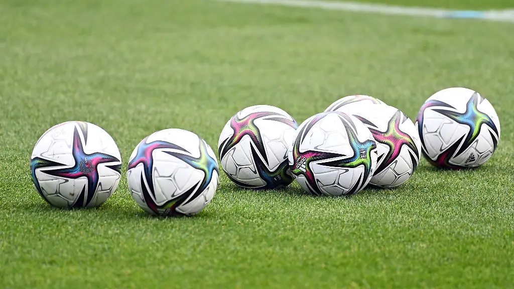 Baelle-liegen-auf-einem-Fussballplatz