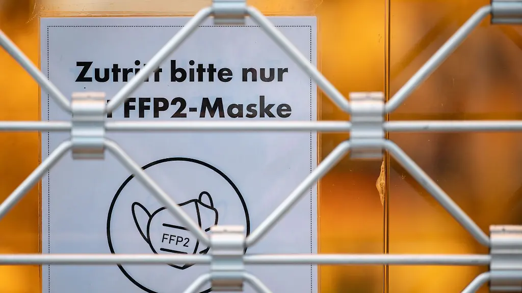 Ein-Schild-am-Eingang-eines-Geschaefts-weist-auf-das-Tragen-einer-FFP2-Maske-hin