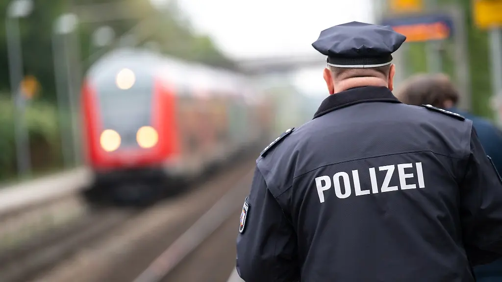 Ein-Polizist-laeuft-ueber-einen-Bahnsteig