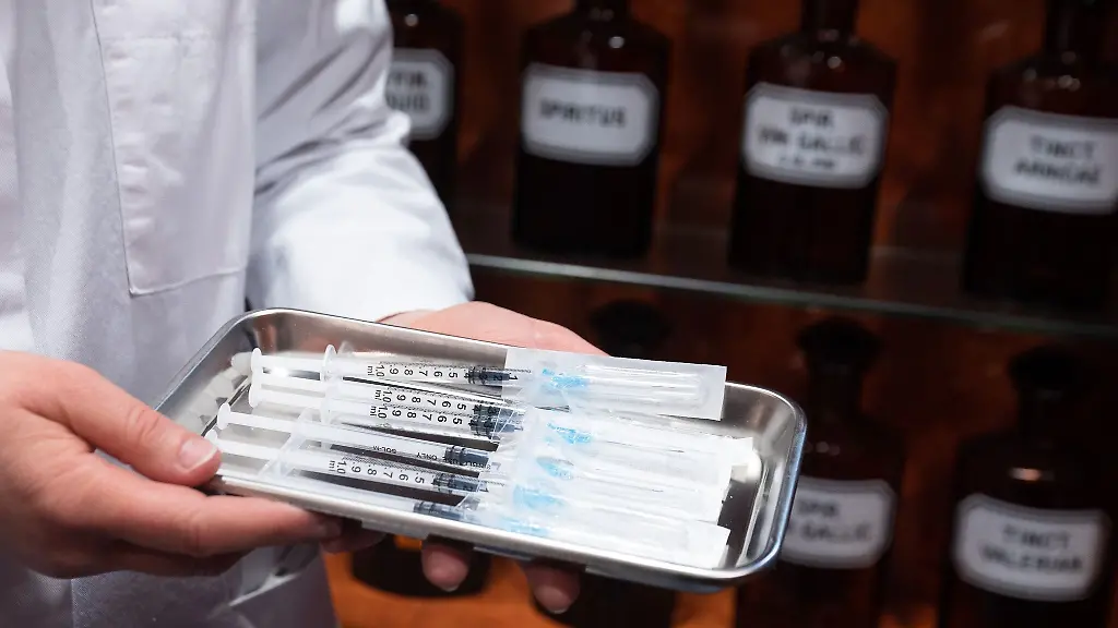 Julia-Sachse-Apothekerin-steht-in-ihrer-Apotheke-mit-einem-Tablett-mit-dem-Corona-Impstoff-von-Biontech