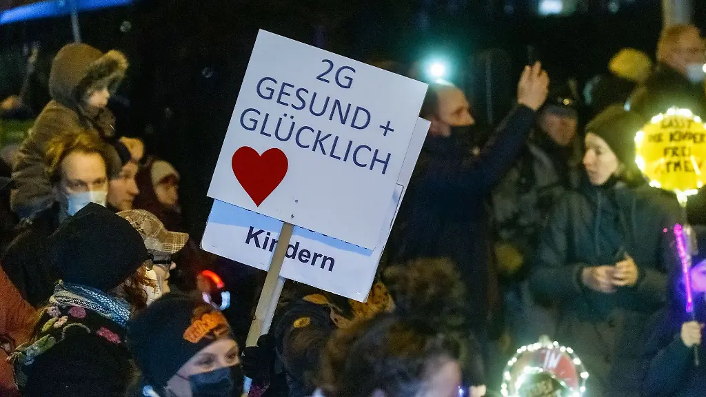 Demonstranten-halten-Schilder-mit-den-Aufschriften-2G-Gesund-und-Gluecklich-und-Haende-weg-von-unseren-Kindern-halb-verdeckt
