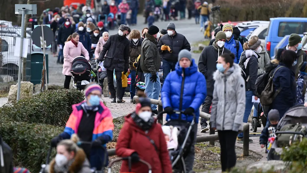 Familien-stehen-vor-der-Wiedereroeffnung-des-Opel-Zoos-im-Maerz-vor-dem-Eingang-Schlange