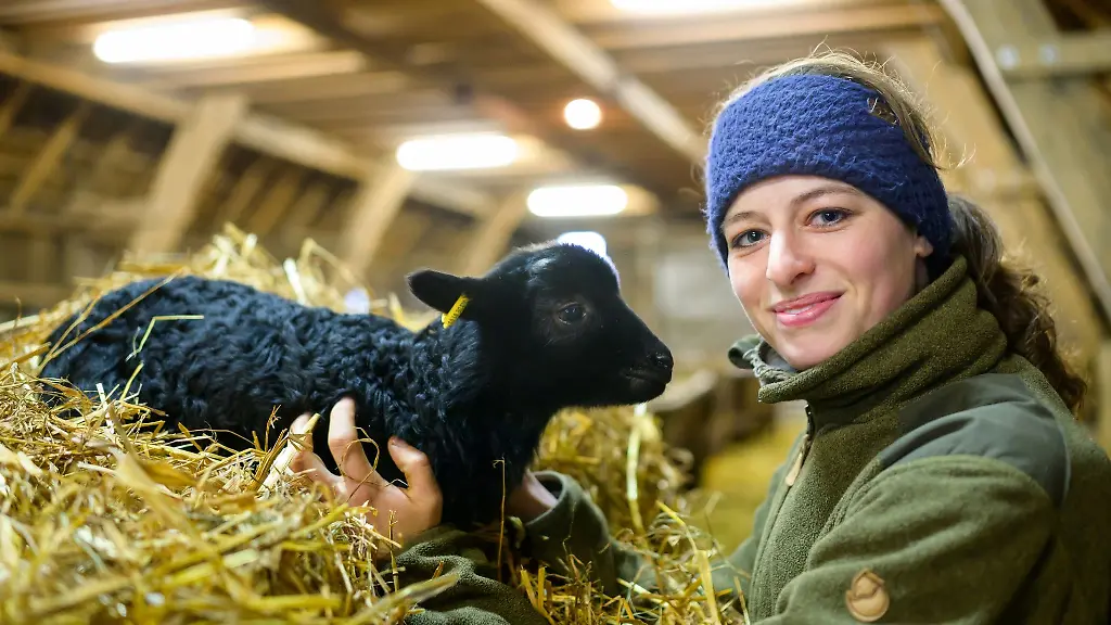 Josefine-Schoen-Schaeferin-haelt-ein-Heidschnuckenlamm-in-den-Haenden