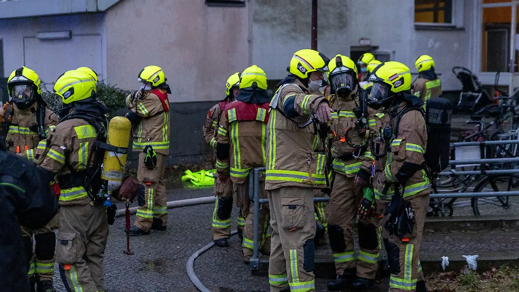 Feuerwehrleute-stehen-vor-dem-Heim-fuer-wohnungslose-Menschen