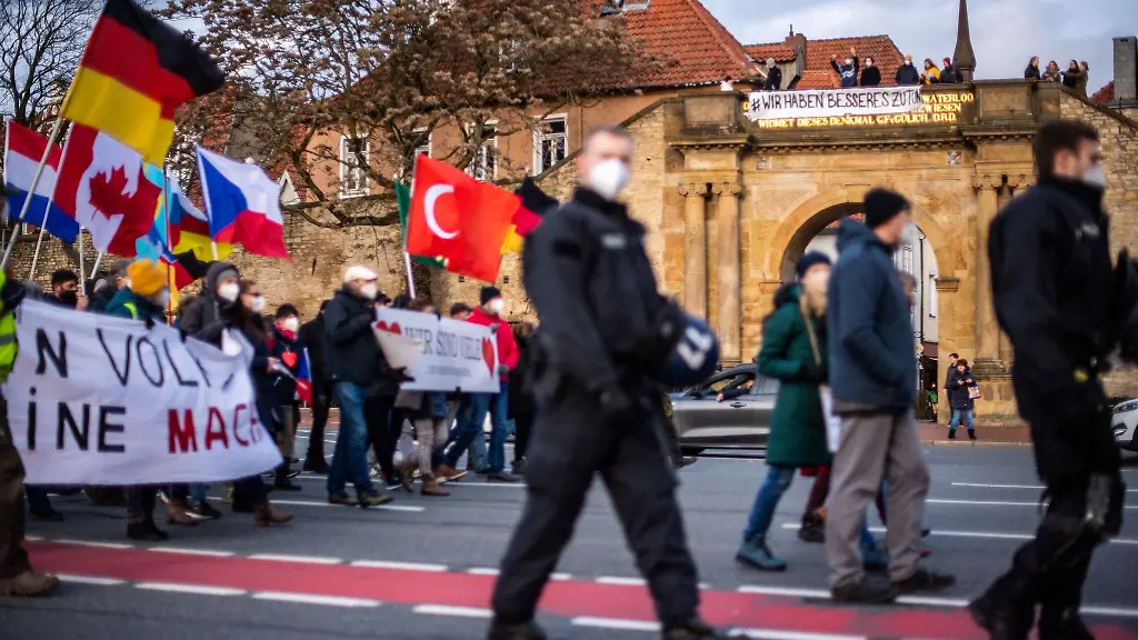 Gegendemonstranten-stehen-auf-dem-Waterloo-Tor-waehrend-Demonstranten-gegen-die-Corona-Massnahmen-an-ihnen-vorbeiziehen