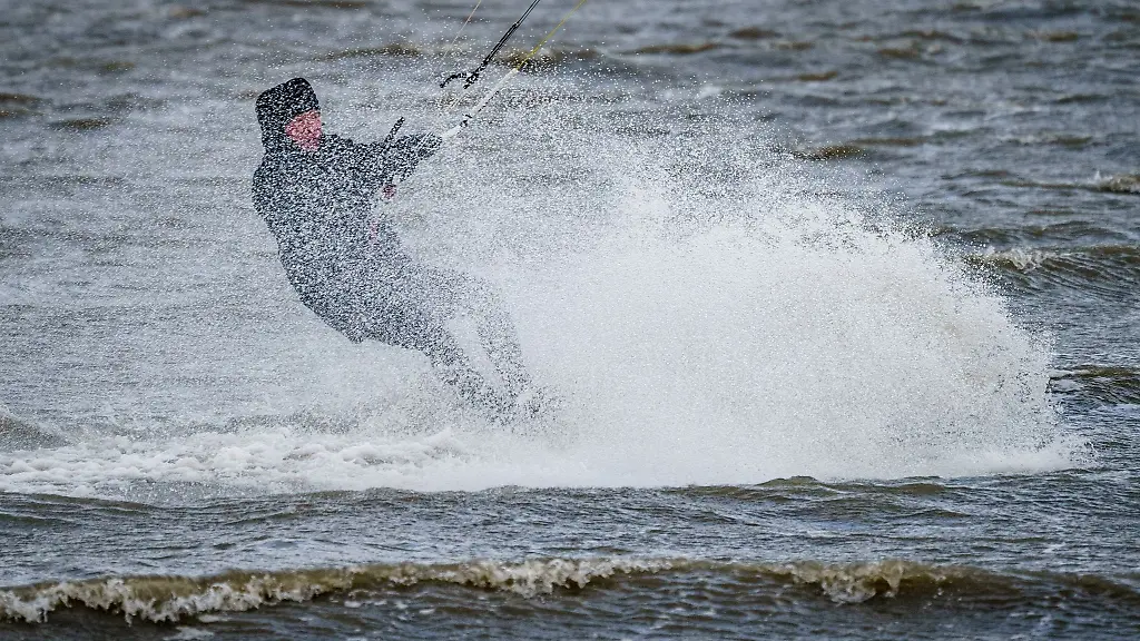 Ein-Kitesurfer-zieht-im-Meer-seine-Bahnen
