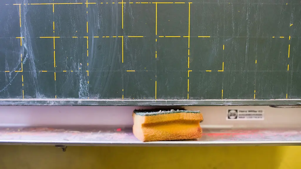 Ein-Schwamm-liegt-in-einer-Grundschule-in-der-Ablage-einer-Kreidetafel