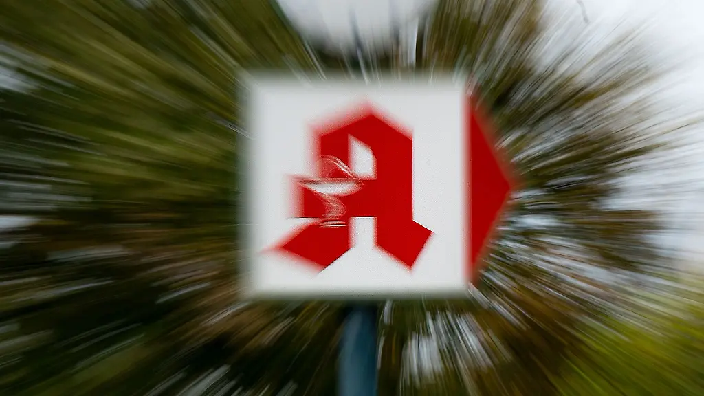 Ein-Schild-mit-dem-Apotheken-Logo-weist-den-weg-zu-einer-Apotheke