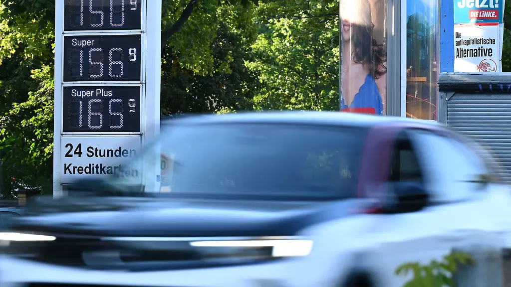 Ein-Auto-faehrt-an-der-elektronischen-Preissaeule-einer-Tankstelle-vorbei