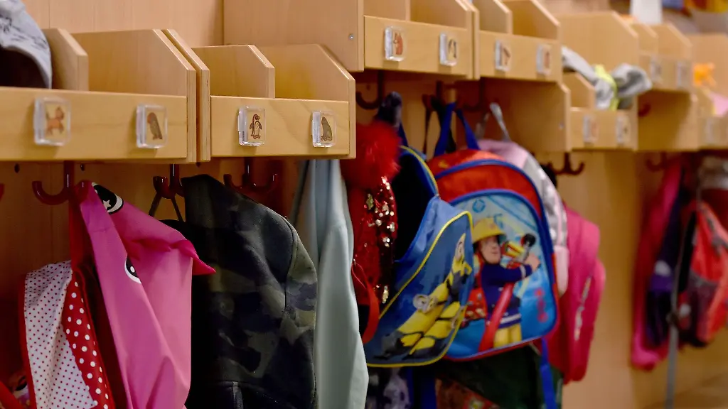 Jacken-und-Rucksaecke-haengen-in-einer-Staedtischen-Kita-an-Haken-im-Flur