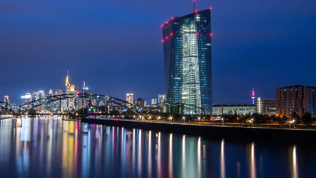 Die-Lichter-der-Europaeischen-Zentralbank-sowie-der-Frankfurter-Bankenskyline-spiegeln-sich-im-Main