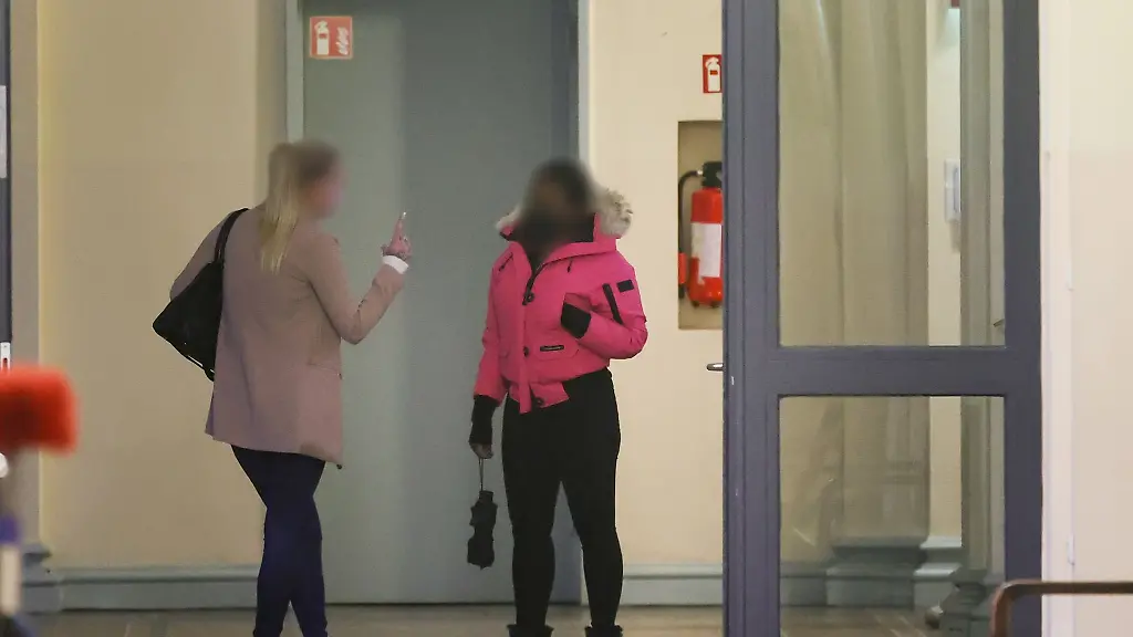 Zwei-angeklagte-Frauen-warten-vor-einem-Gerichtssaal-auf-den-Beginn-der-Verhandlung