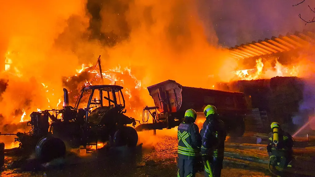 Feuerwehrleute-loeschen-ein-Grossfeuer-auf-einem-Bauernhof