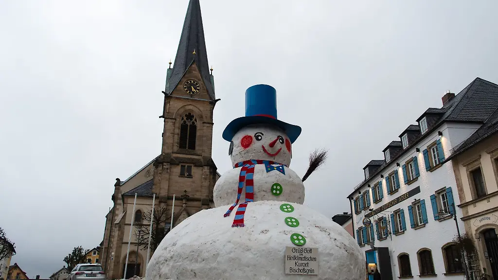 Mit-Zylinder-rosa-Wangen-und-spitzer-Nase-thront-der-Riesenschneemann-mitten-in-Bischofsgruen