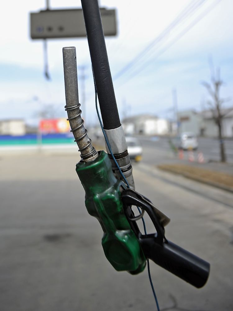Die Pistole einer Zapfsäule hängt an einer geschlossenen Tankstelle in der Nähe von Kagamiishi in Japan. Auch in nicht unmittelbar betroffenen Teilen des Landes machen sich die Folgen der Naturkatastrophe bemerkbar.