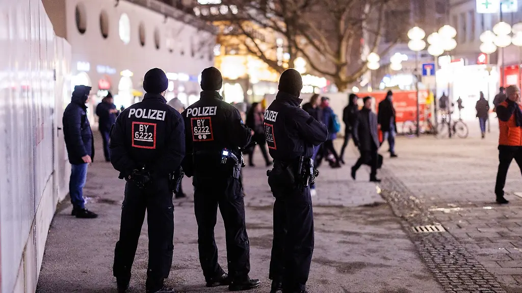 Polizeibeamte-beobachten-eine-Demonstration-gegen-die-Corona-Massnahmen-in-einer-Einkaufsstrasse-in-Muenchen