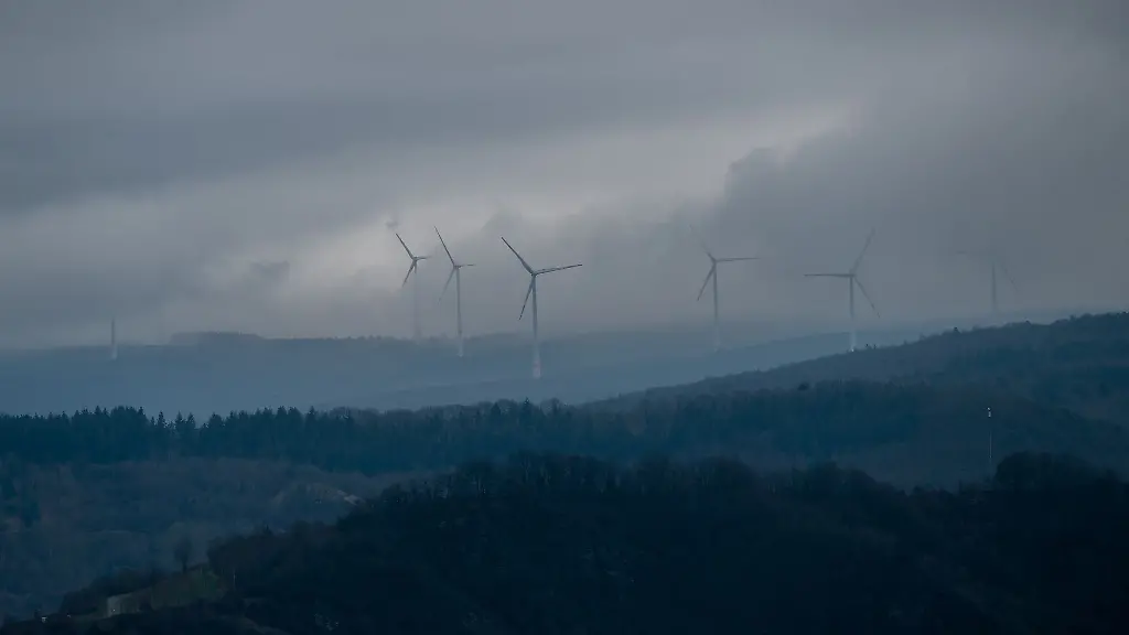 Dichte-Wolken-haengen-ueber-Bergen-und-Windraedern-oberhalb-der-Mosel