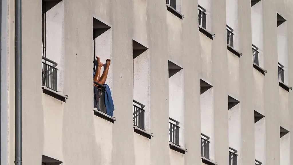 Eine-Person-sonnt-in-einem-Mehrfamilienhaus-in-der-Herbstsonne-ihre-Beine