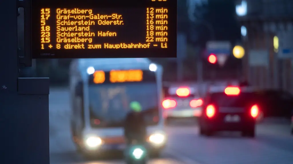 Ein-Bus-steht-hinter-einer-elektronischen-Fahrplananzeige