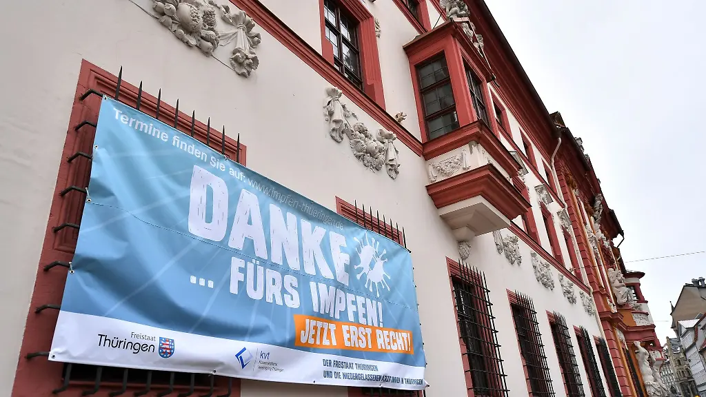Ein-Transparent-mit-der-Aufschrift-Danke-fuers-impfen-Jetzt-erst-recht-haengt-an-der-Thueringer-Staatskanzlei