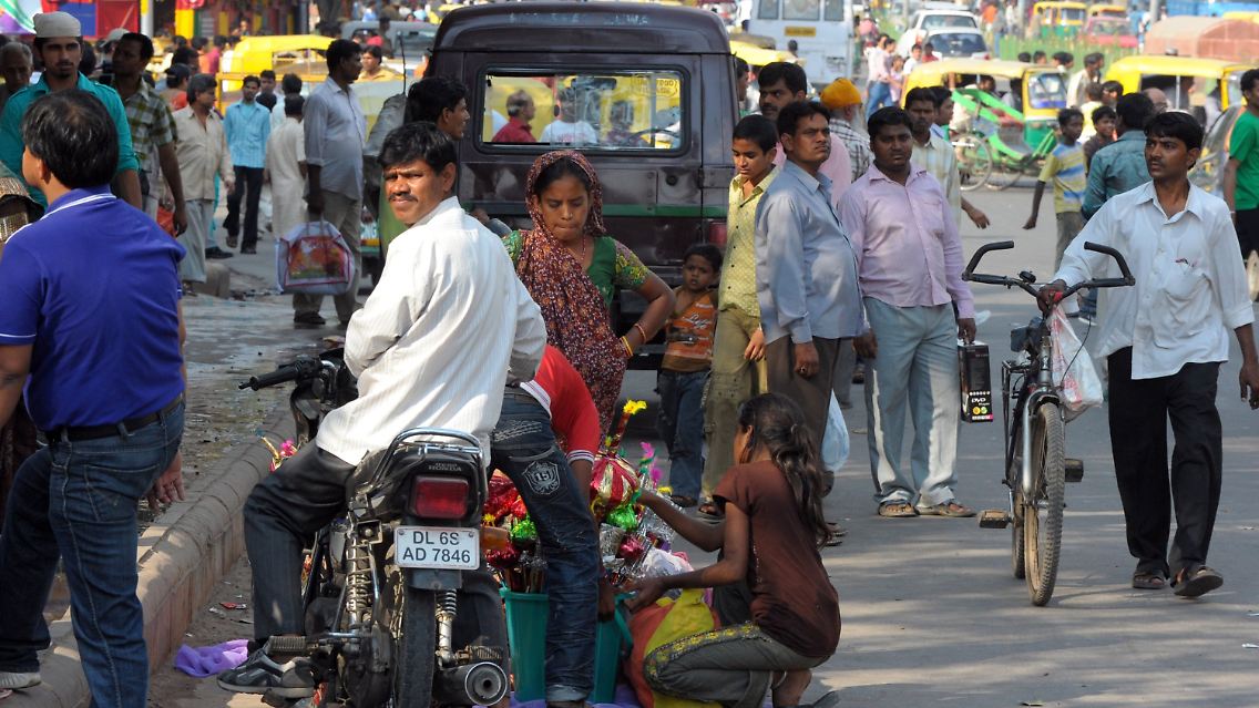 Verhältnis von 113 zu 100: Männer und Frauen auf einer Straße in Deu Delhi, Indien.