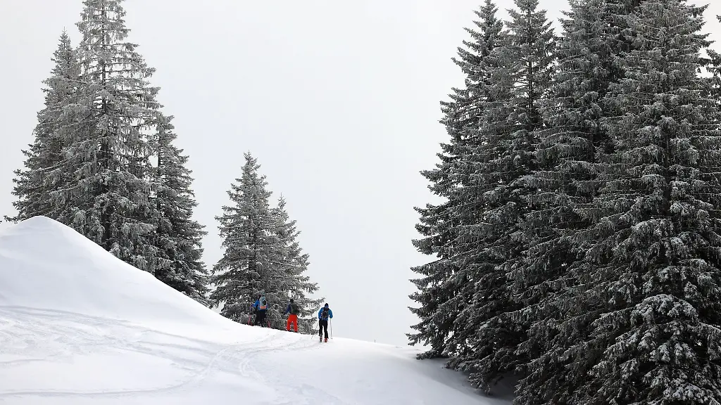 Tourengeher-durchstreifen-die-mit-Neuschnee-bedeckte-Landschaft-im-Skigebiet-Grasgehren
