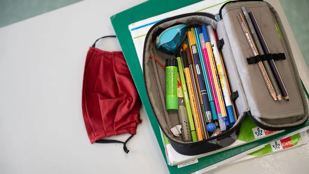 Eine-Atemschutzmaske-liegt-neben-einem-Federmaeppchen