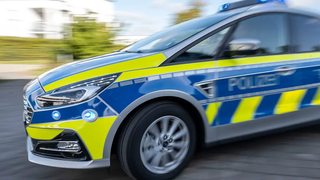 Ein-Polizeiwagen-faehrt-mit-eingeschaltetem-Blaulicht