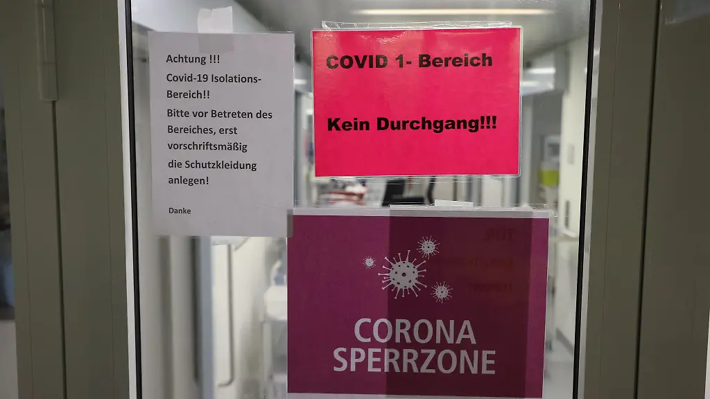 Hinweisschilder-haengen-am-Eingang-der-Covid-19-Intensivstation-in-einer-Klinik