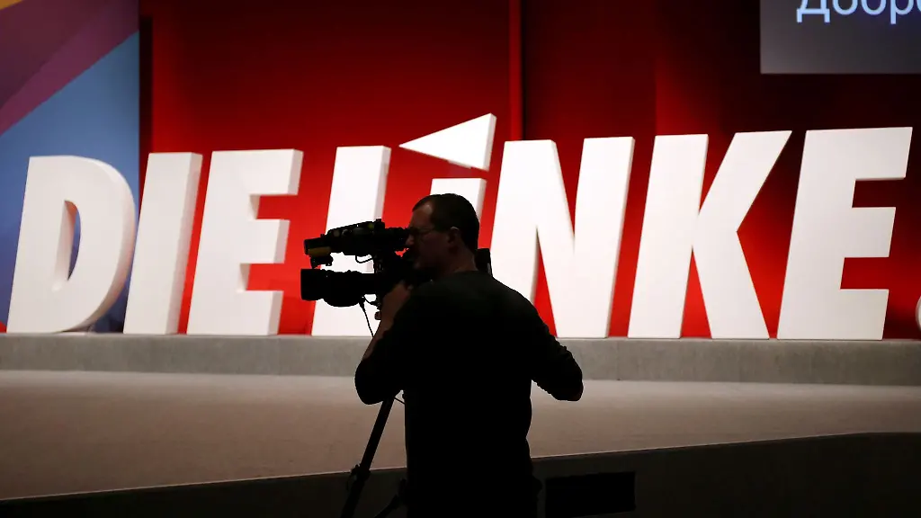 Ein-Kameramann-steht-vor-dem-Logo-der-Linkspartei
