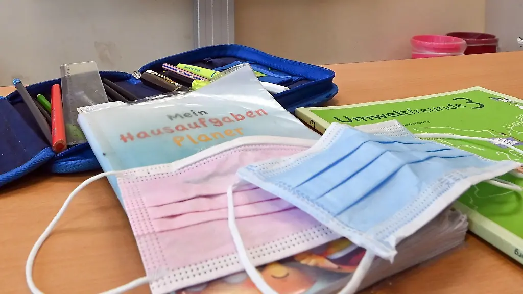 Masken-und-Arbeitsmaterialien-liegen-in-einem-Klassenraum