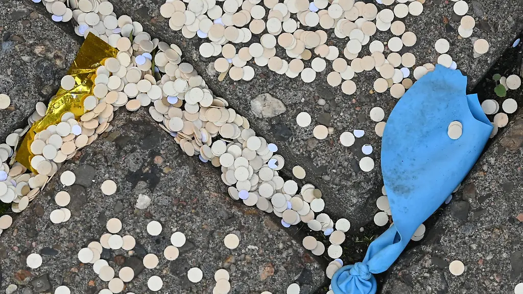 Konfetti-und-ein-kaputter-Luftballon-liegen-auf-einem-Gehweg