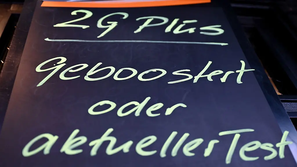 Am-Eingang-einer-Kneipe-haengt-ein-Hinweis-mit-der-Aufschrift-2G-Plus-geboostert-oder-aktueller-Test