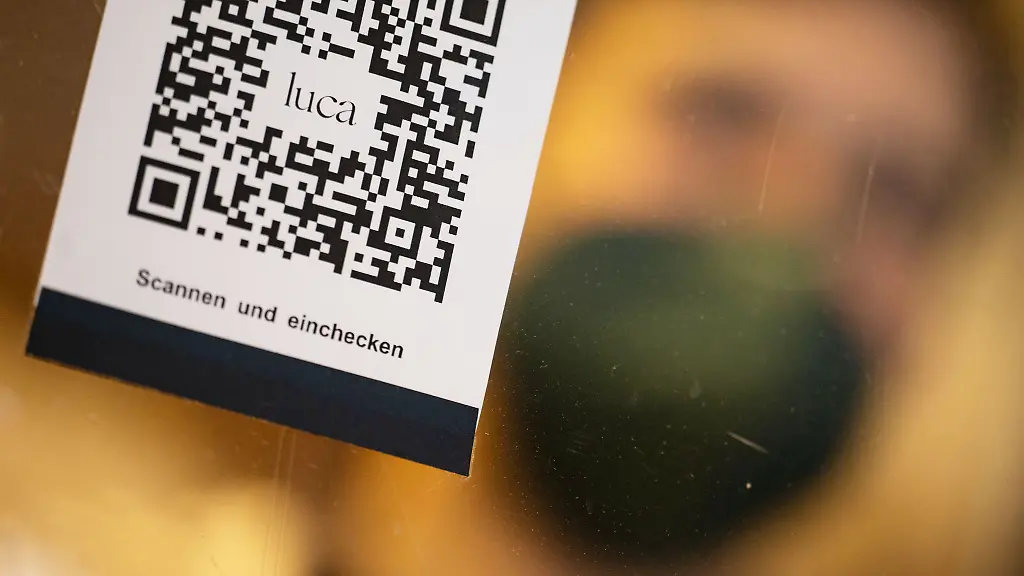 Ein-Barcode-der-mit-der-Luca-App-zur-Kontaktnachverfolgung-gescannt-werden-kann-haengt-in-einem-Einzelhandelsgeschaeft-an-einer-Schutzscheibe