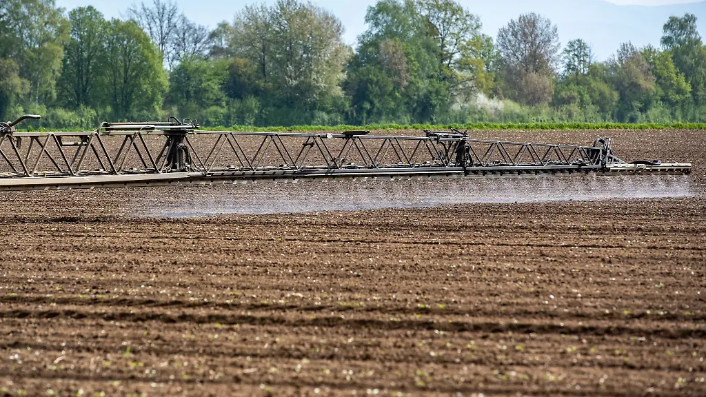 Ein-Traktor-mit-einem-GPS-Lenksystem-bringt-auf-einem-Acker-Pflanzenschutzmittel-aus
