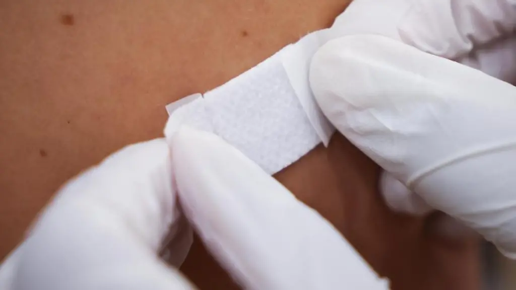 Eine-Aerztin-klebt-einem-Mann-nach-der-Impfung-ein-Pflaster-auf-den-Arm