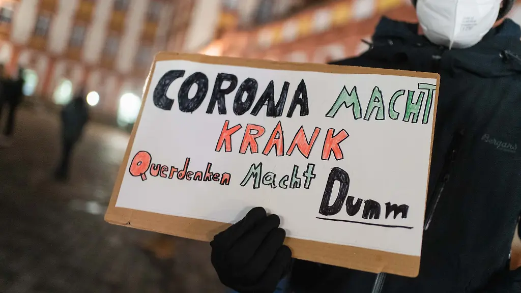 Ein-Mann-haelt-bei-einer-Gegendemonstration-ein-Schild-mit-Aufschrift