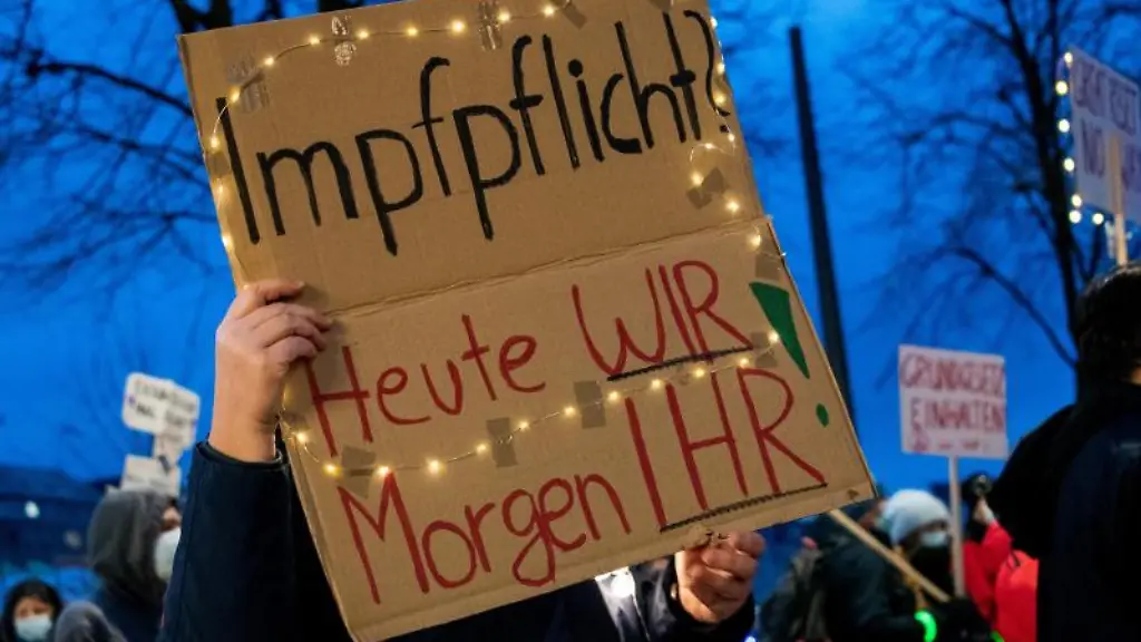 Eine-Teilnehmerin-einer-Demonstration-gegen-Corona-Einschraenkungen-haelt-ein-Schild