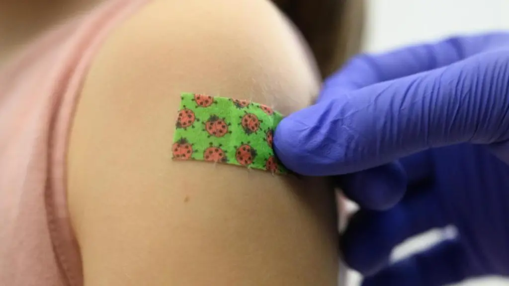 Ein-Maedchen-bekommt-nach-der-Impfung-ein-Pflaster-auf-den-Arm-geklebt