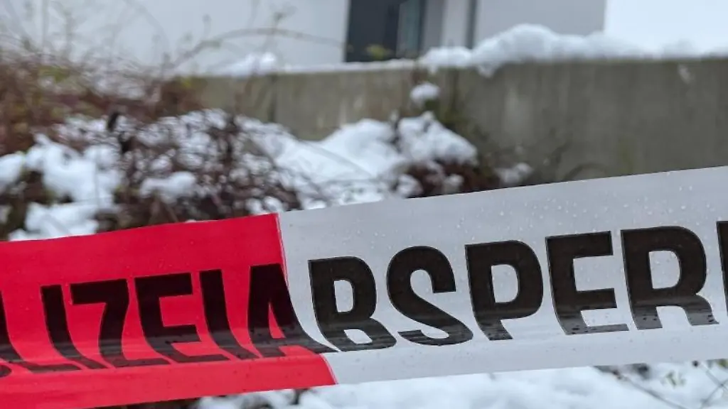 Ein-Absperrband-der-Polizei-ist-vor-einem-Einfamilienhaus-gespannt