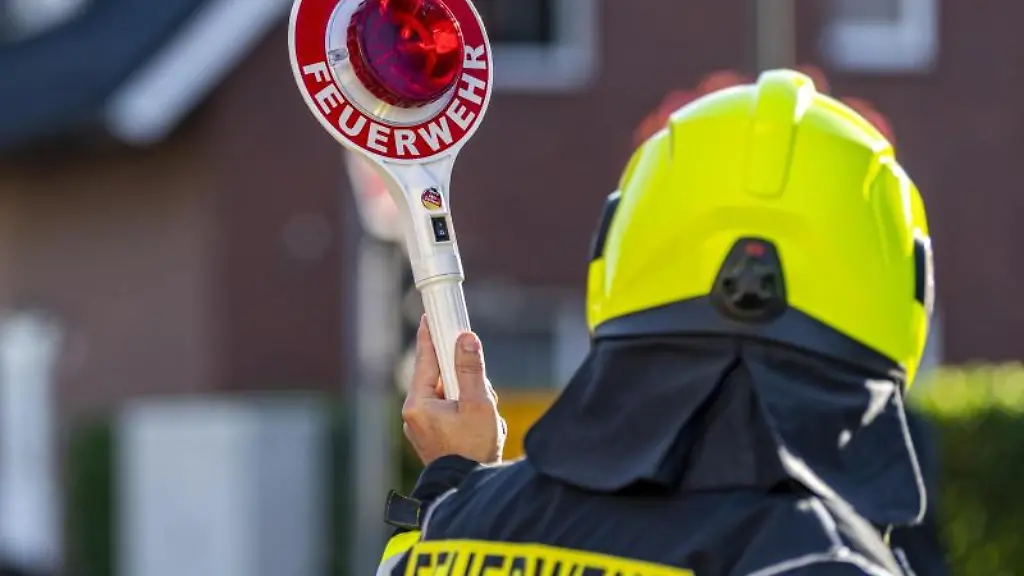 Ein-Feuerwehrmann-haelt-eine-Winkerkelle-in-der-Hand